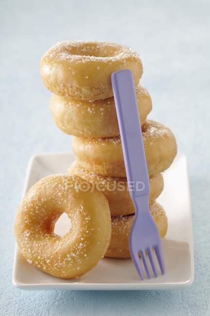 Donuts de açúcar empilhados na bandeja — Fotografia de Stock