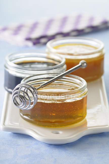 Pots of honey and spoon — Stock Photo