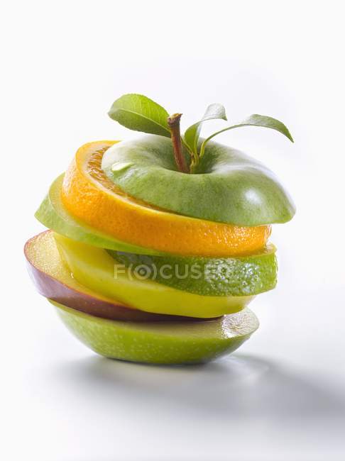 Manzana apilada en rodajas con naranja - foto de stock