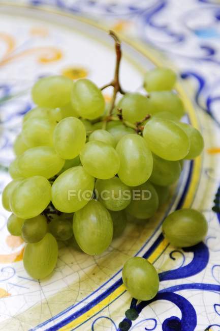 Uvas frescas y maduras en plato - foto de stock