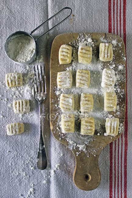 Homemade gnocchi on wooden board — Stock Photo