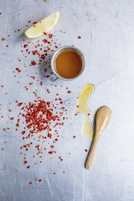 Top view of chilli flakes and sauce with lemon wedge — Stock Photo