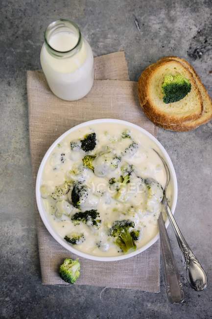 Broccoli in bechamel sauce  on white plate over plate — Stock Photo