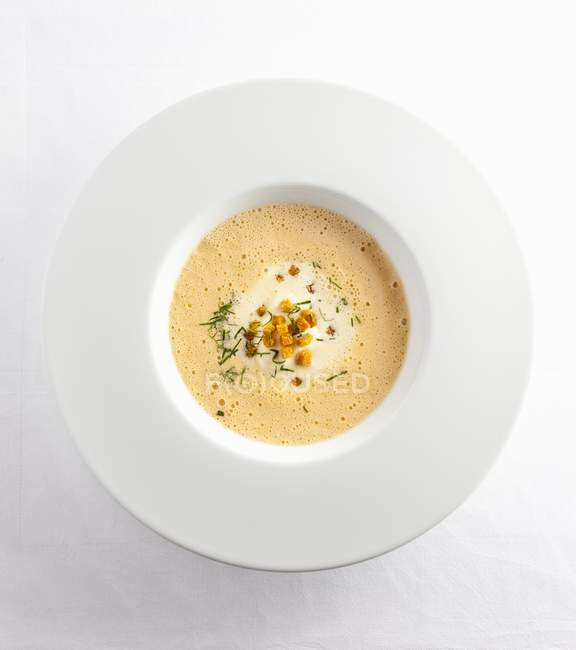 Blick von oben auf schaumige Weißweinsuppe mit Croutons und Rosmarin — Stockfoto