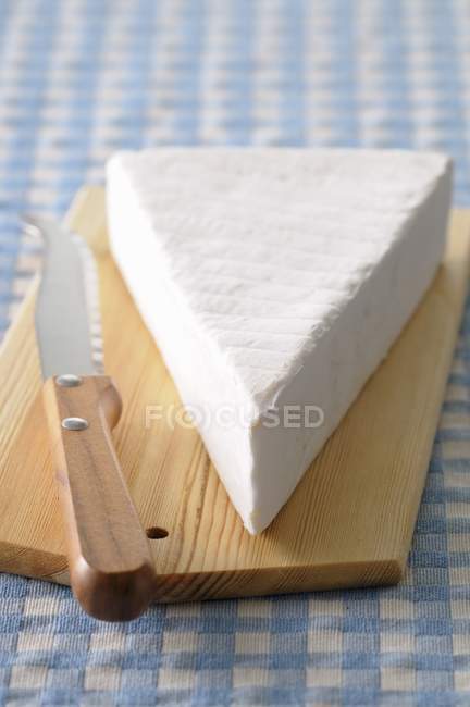 Morceau de Brie sur planche de bois — Photo de stock