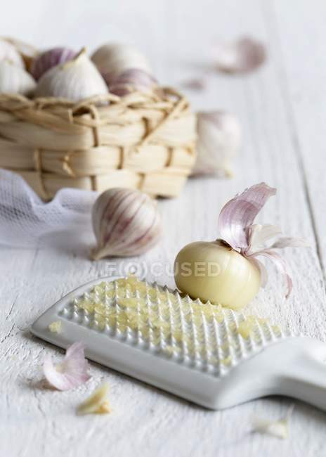 Peeled garlic clove with grater — Stock Photo
