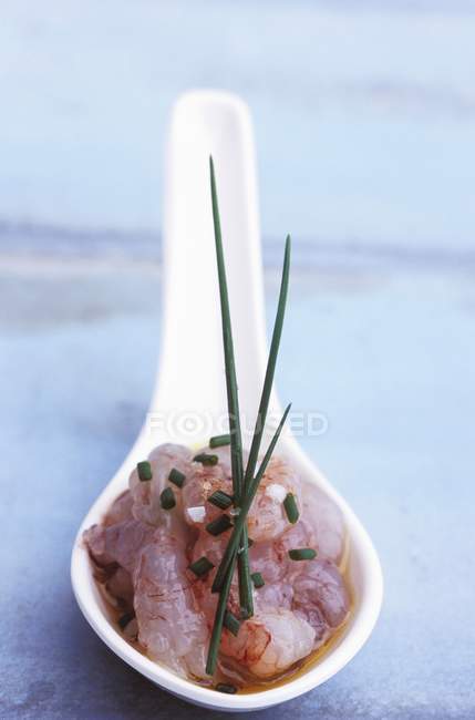 Closeup view of prawn Tatar with chives in ceramic spoon — Stock Photo