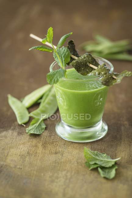 A vegan shot with sugar snaps, seaweed bacon and mint on wooden surface — Stock Photo