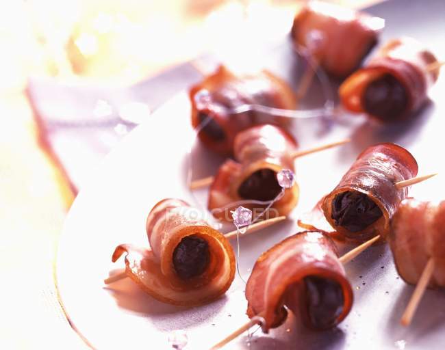 Prunes wrapped in bacon — Stock Photo