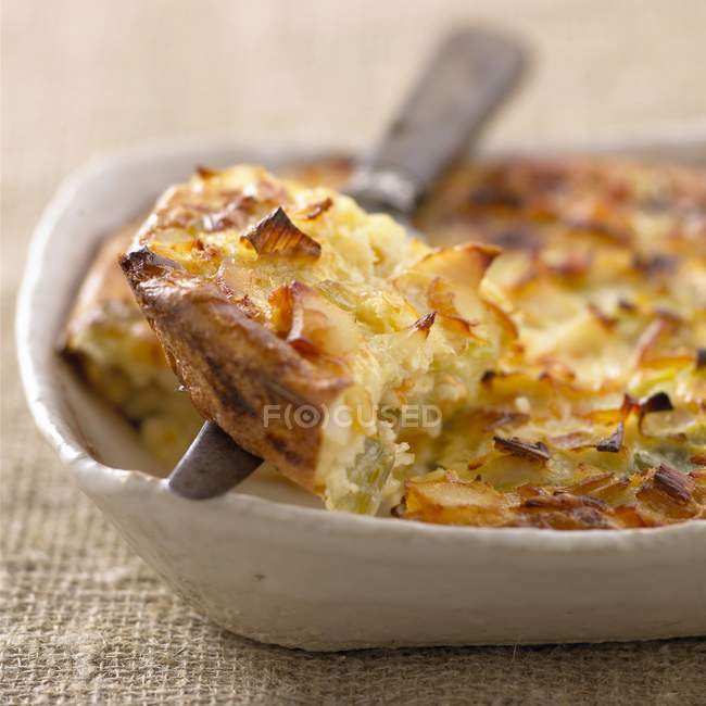 Haddock and leek Clafoutis on dish with knife — Stock Photo