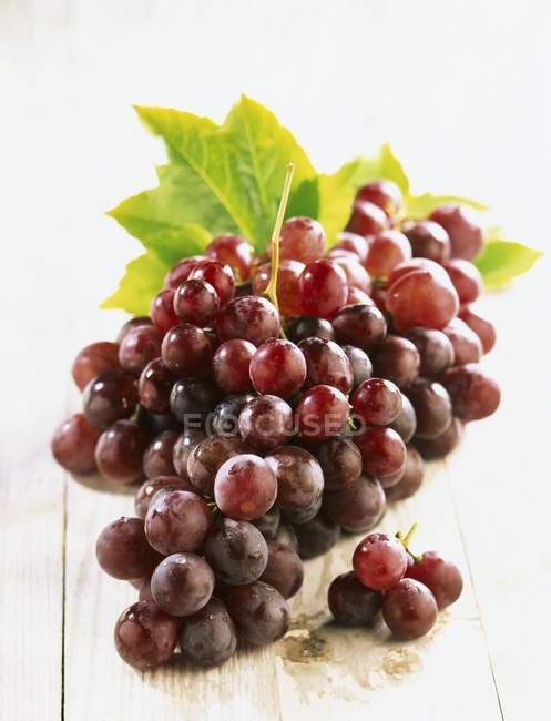 Ripe Cardinal grapes on wooden table — Stock Photo