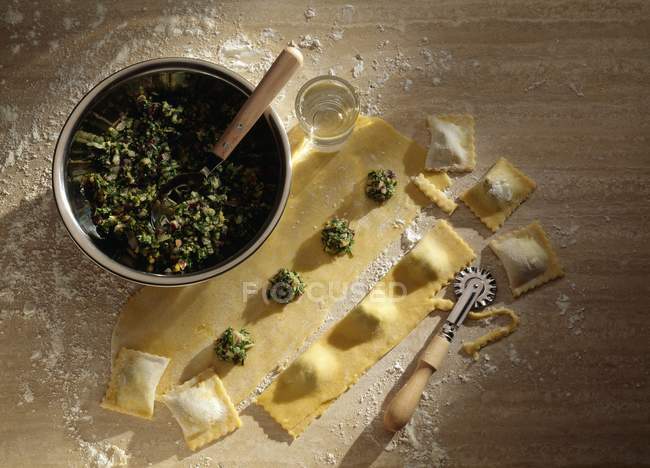 Stuffing ravioli pasta with spinach — Stock Photo
