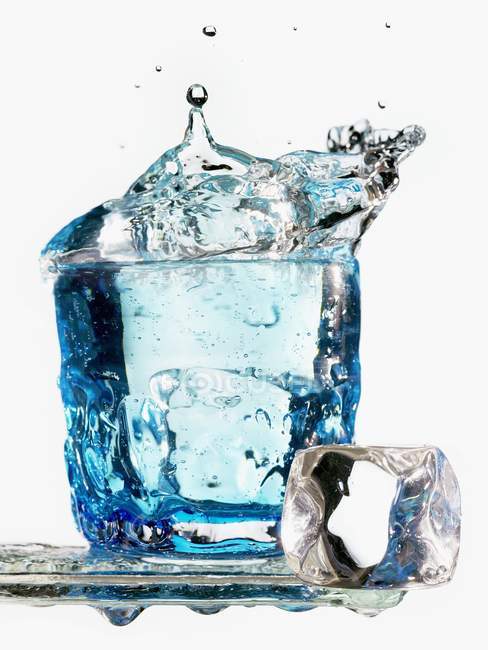 Cubo de hielo cayendo en un vaso de agua - foto de stock