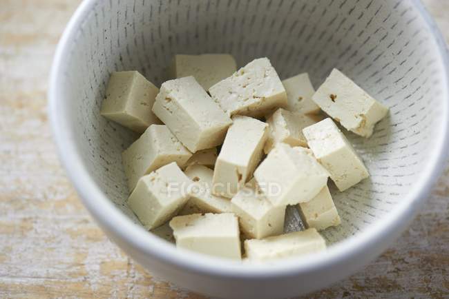 Vista de cerca del queso de tofu cortado en cubitos en un plato - foto de stock