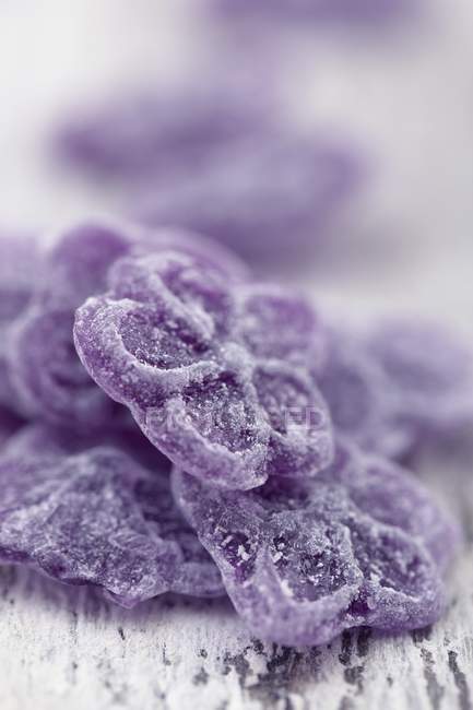 Vista de cerca de los caramelos en forma de flor violeta - foto de stock
