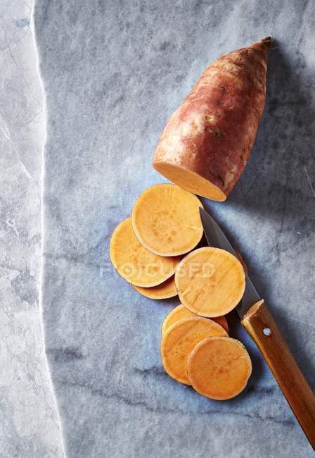 Частично нарезанный сладкий картофель — стоковое фото