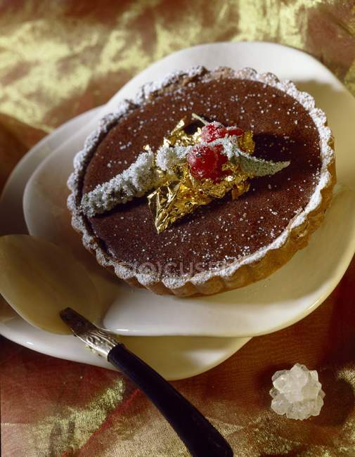 Chocolate tartlet decorated with golden leaf — Stock Photo