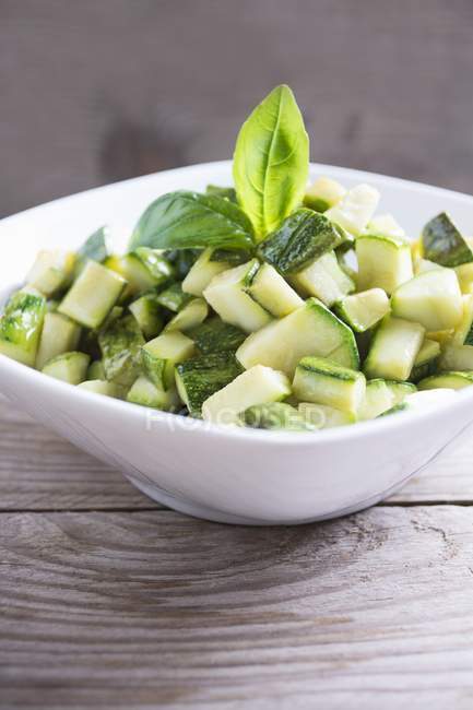 Diced zucchini in a bowl on a wood table — Stock Photo