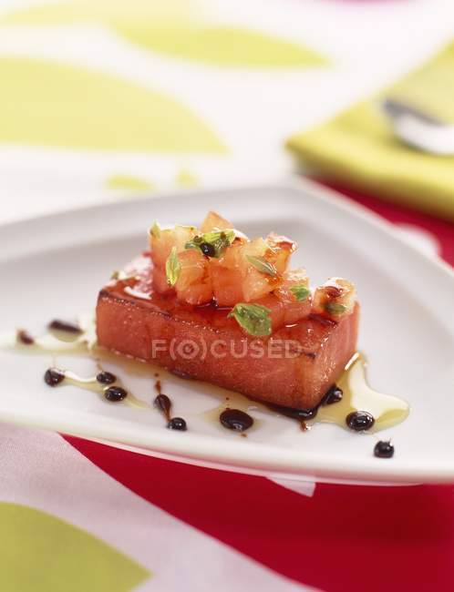 Ломтик мяса в соусе и с овощами на белой тарелке — стоковое фото