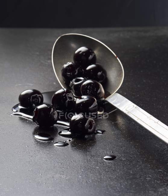 Black olives on spoon — Stock Photo