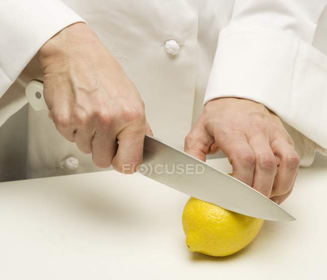 Homme tranchant le citron — Photo de stock