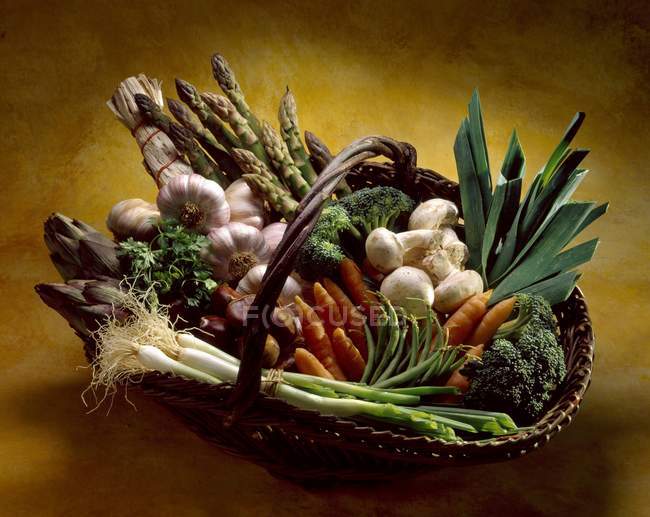 Basket of vegetables on brown background — Stock Photo