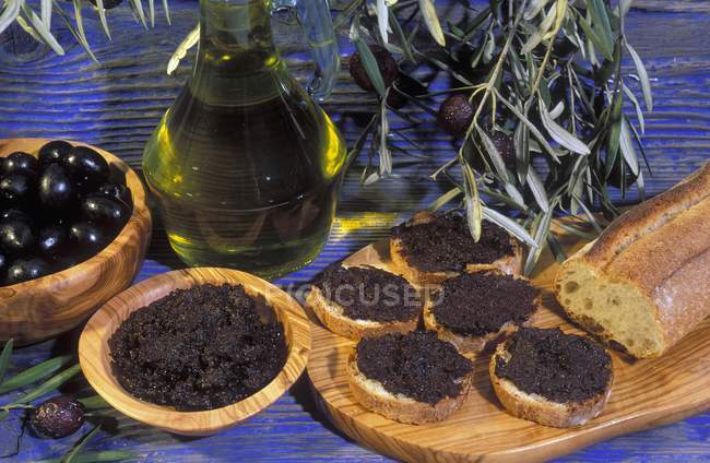 Tapenade in wooden bowls and on wooden desk over table — Stock Photo
