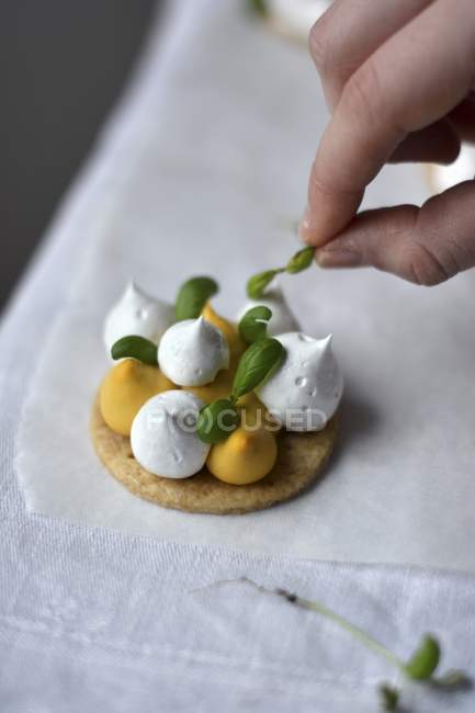 Hand garnishing Lemon meringue tart — Stock Photo