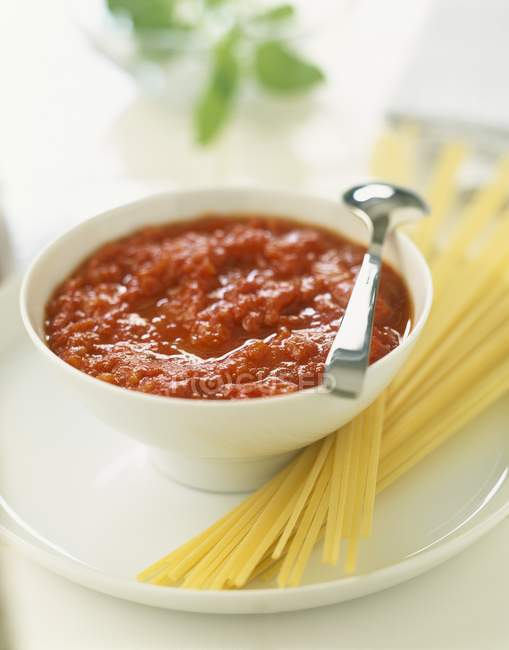 Massa de espaguete não cozida com molho de tomate — Fotografia de Stock