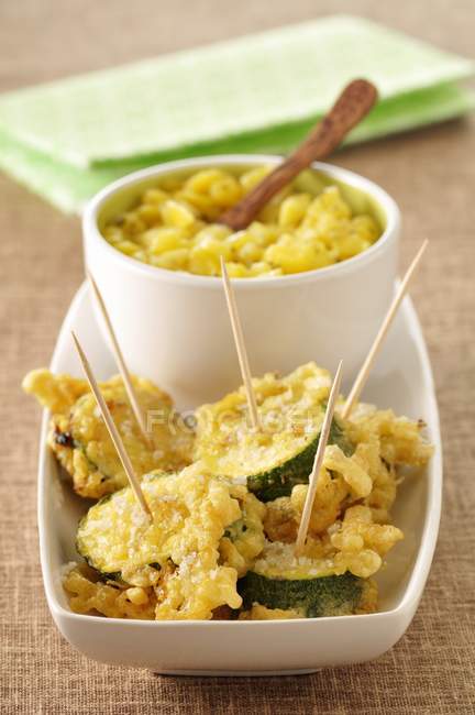 Zucchini tempuras with mango and ginger chutney in white bowl over plate — Stock Photo