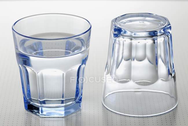 Vaso de agua y vaso vacío - foto de stock