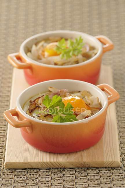 Coddled egg with shallots in orange pots over desk — Stock Photo