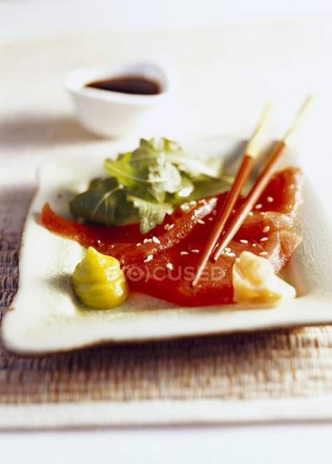 Tuna sashimi on white plate over straw mat — Stock Photo