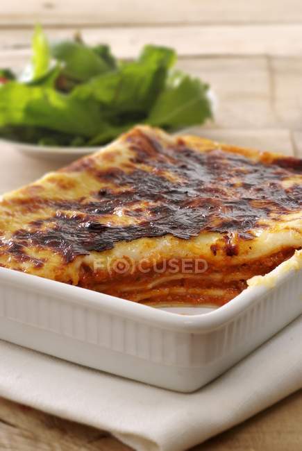 Couper les lasagnes cuites au four dans un plat de cuisson — Photo de stock