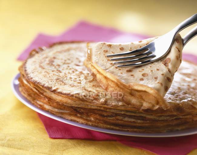 Crepes with fork and on plate — Stock Photo