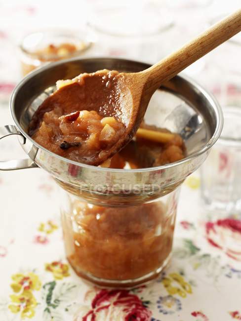 Preparing pear chutney in small pan over cup — Stock Photo