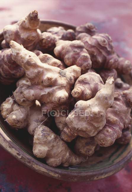 Bowl of fresh ginger roots — Stock Photo