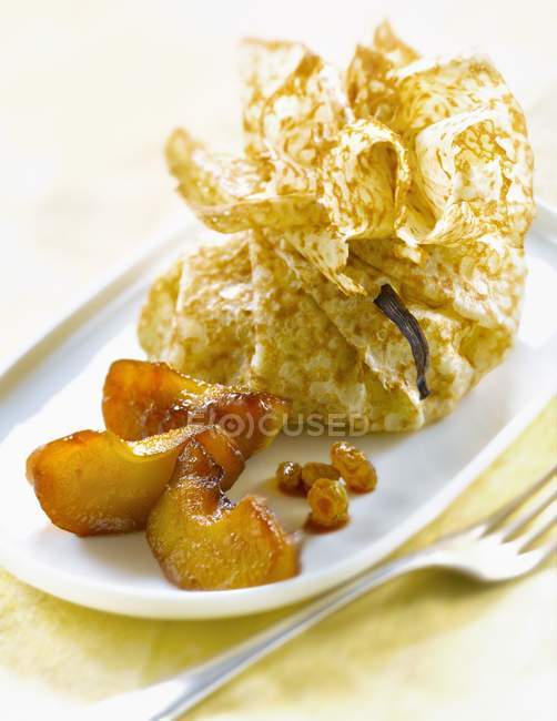 Caramelized apple and raisin purse on white plate — Stock Photo