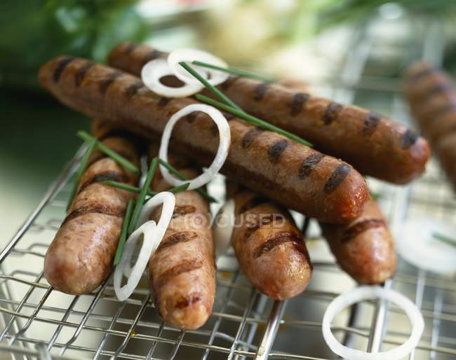 Salsicce alla griglia con anelli di cipolla — Foto stock