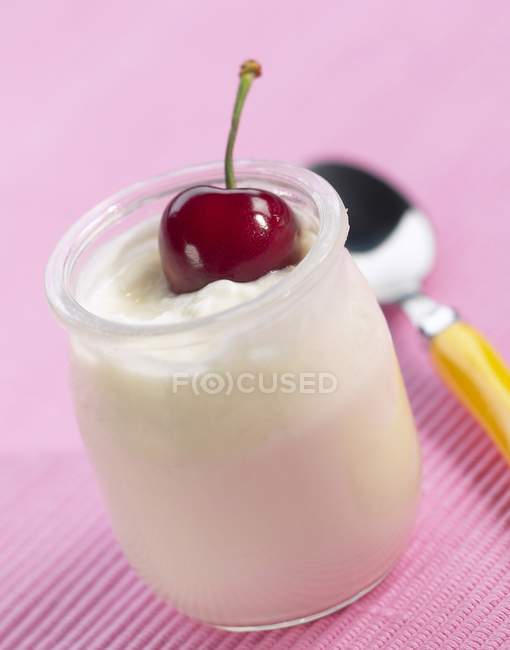 Yogurt with cherry in glass cup — Stock Photo