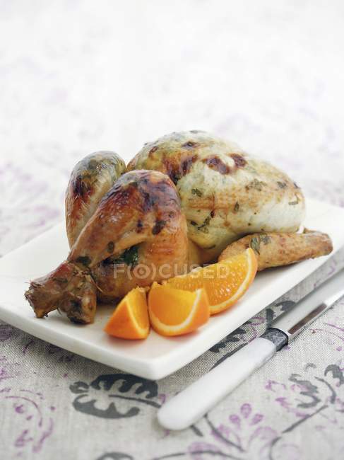 Pollo asado con rodajas de naranja - foto de stock