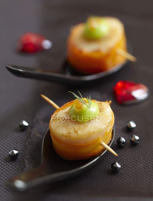 Scallop and carrot Makis over black surface — Stock Photo