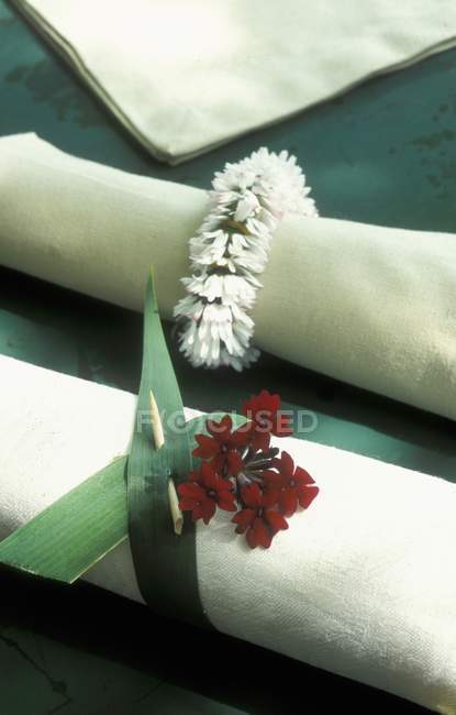Vista de cerca de una servilleta de tela blanca con una decoración floral - foto de stock