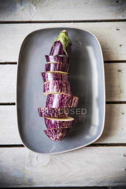 Ein Stapel aufgeschnittener Auberginen auf grauer Holzoberfläche — Stockfoto