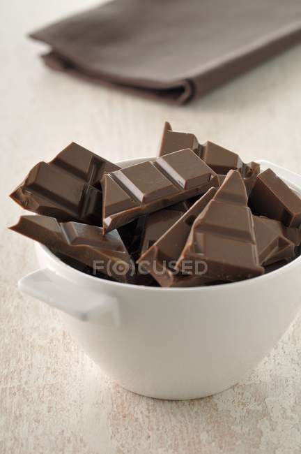 Squares of chocolate in bowl — Stock Photo