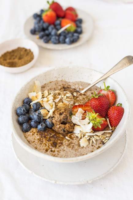 Coconut linseed porridge with berries — Stock Photo