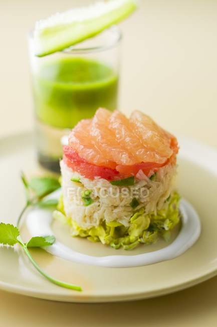 Fish Tartare with pink grapefruit on white plate on blurred background — Stock Photo
