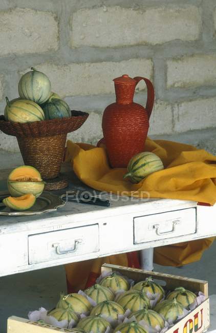 Провенальное расположение дынь и плетеной посуды на кирпичной стене — стоковое фото