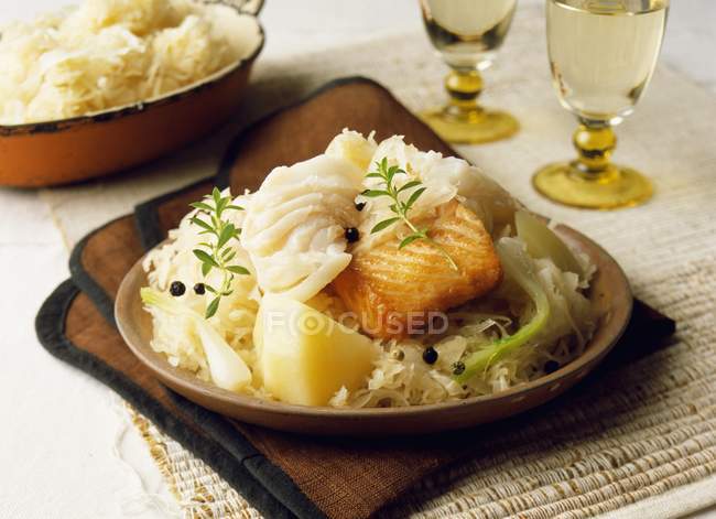 Fish Choucroute on brown plate over towel on table — Stock Photo