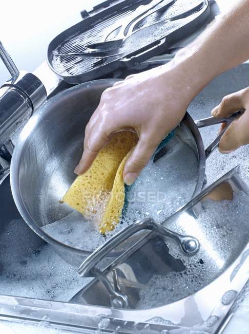 Visão elevada de mãos lavar pratos em pia — Fotografia de Stock